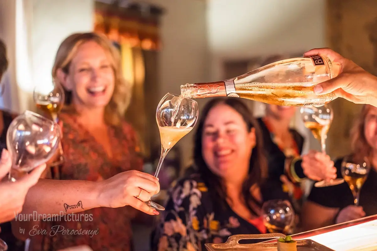 A glass of champagne while people are smiling
