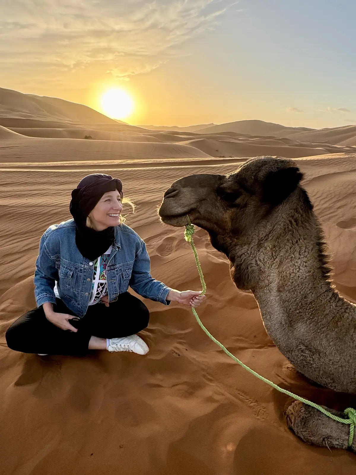 Julie Hartigan with a camel in the Sahara at sunset