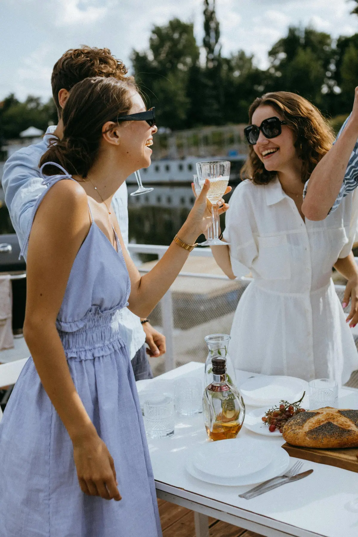 Friends sharing drinks at a lakeside lunch