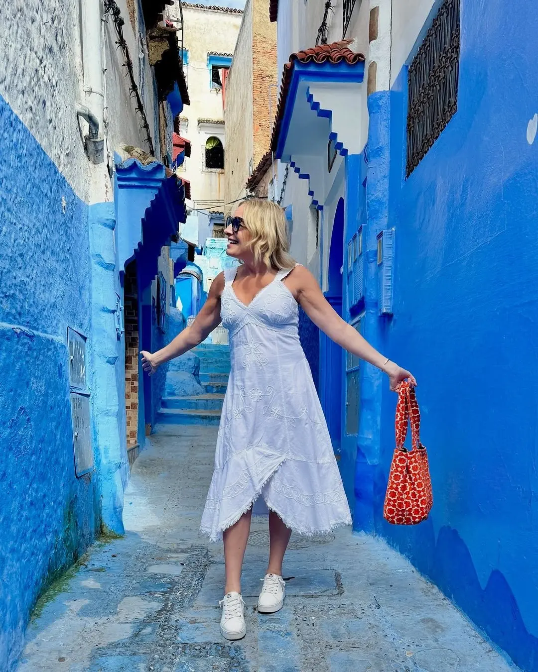 Julie Hartigan strolling around a blue street in Morocco